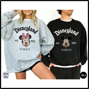 Pu&ograve; includere: Due felpe, una grigio sport e una nera, con il logo Disneyland e Minnie e Topolino. Il testo recita "Disneyland est. 1983 TOKYO". La felpa di Minnie Mouse ha un fiocco a pois rossi e bianchi.