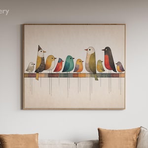 Op de afbeelding: Een ingelijst kunstwerk met een rij kleurrijke vogels die op een lijn zitten. De vogels zijn afgebeeld in verschillende kleuren, waaronder geel, blauw en rood. Het kunstwerk wordt tentoongesteld boven een lichtgekleurde hoekbank met bruine sierkussens.