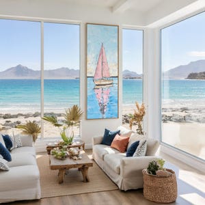 May include: A coastal-themed living room with large windows overlooking a beach and ocean. Two white sofas with blue and orange accent pillows face a wooden coffee table. A framed painting of a sailboat with a pink sail hangs on the wall.