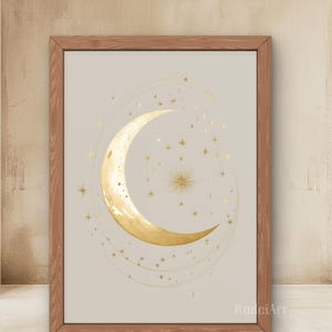 Pode incluir: Uma impressão emoldurada com uma lua crescente dourada e estrelas em um fundo bege. A obra de arte tem um tema celestial, com uma lua central e estrelas ao redor, todas em ouro. A moldura é de madeira.