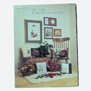 May include: A Thrifty Craft instructional booklet titled This is... a summer dream. The cover displays a collection of embroidered pillows, a rug, and framed floral needlework art arranged around a wooden chair and a wicker storage chest.