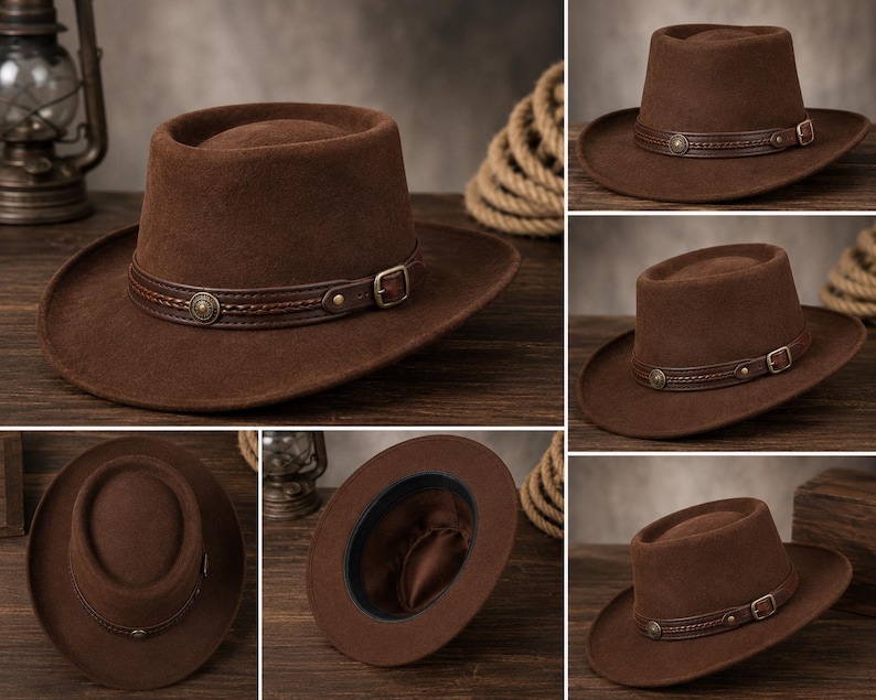 May include: A brown felt hat featuring a flat crown and a wide brim. The hat is accented with a dark brown leather band that includes a braided detail, a metallic circular stud, and a small adjustable metal buckle on the side of the crown.