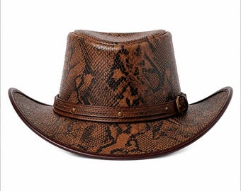 May include: A brown and black snakeskin patterned cowboy hat featuring a structured crown and a curved brim. The hat is accented with a dark brown leather band that includes small metallic studs and a side buckle closure for adjustment.