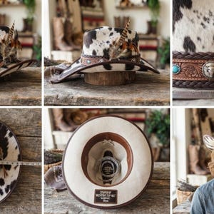 May include: A cowhide print cowboy hat featuring a brown leather band with braided edges, silver-toned metal accents, a turquoise stone, and decorative feathers. A measuring tape shows the hat has a diameter of approximately 15 inches.