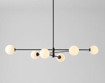 May include: A modern black chandelier with six spherical, frosted glass light bulbs. The fixture has a minimalist design, with a central hub and horizontal arms extending outwards. The light bulbs are evenly spaced along the arms.