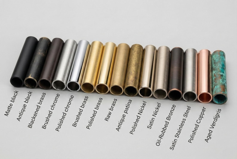 May include: A collection of fifteen cylindrical metal samples arranged in a row, each featuring a distinct finish labeled as matte black, antique black, blackened brass, brushed chrome, polished chrome, brushed brass, polished brass, raw brass, antique patina, polished nickel, satin nickel, oil-rubbed bronze, satin stainless steel, polished copper, and aged verdigris.
