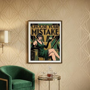 May include: A framed art print featuring a woman in a green dress holding a cocktail, with the text "CHOOSE YOUR MISTAKE" in gold and green. The artwork has a vintage, art deco style. The print is displayed on a patterned wall.