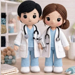 May include: Two crocheted doctor dolls, one with black hair and the other with brown hair, wearing blue scrubs and white lab coats. Each doll has a stethoscope and one holds a syringe. The dolls are handmade and have large, expressive eyes.