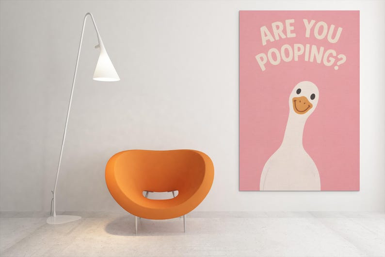 Puede incluir: Un interior moderno con una silla naranja, una l&aacute;mpara de pie blanca y una obra de arte rosa. La obra muestra un ganso de dibujos animados con el texto "ARE YOU POOPING?" en blanco. La habitaci&oacute;n tiene un dise&ntilde;o minimalista.