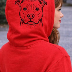 Puede incluir: Una sudadera roja con un dibujo lineal negro de la cara de un perro. El texto "Fits a 140 x 140 mm Hoop" está encima de la imagen del perro. La parte inferior de la imagen contiene el texto: DST, PES, JEF, EXP, HUS, VP3, XXX, CND, PDF.