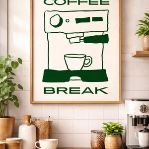 Könnte beinhalten: Ein gerahmter Druck mit einer grünen Illustration einer Kaffeemaschine und den Worten "COFFEE BREAK". Das Kunstwerk wird in einer Küche mit einer Holztheke und verschiedenen Kaffeezubehörteilen präsentiert.