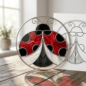 May include: A stained glass ladybug suncatcher with a red and black design, framed in silver metal. The ladybug has black spots and a detailed wing pattern. A line drawing of the ladybug is next to it.