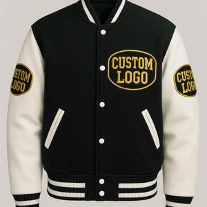 May include: A black varsity jacket with white sleeves, featuring a ribbed collar, cuffs, and hem with white stripes. The jacket has white snap buttons and three oval patches with yellow borders and the text CUSTOM LOGO on the chest and sleeves.
