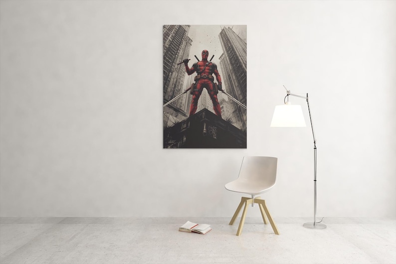 May include: A framed canvas print depicting a red superhero with swords, set against a cityscape. The artwork is mounted on a white wall, above a chair and a floor lamp. The print is a striking piece of wall art.