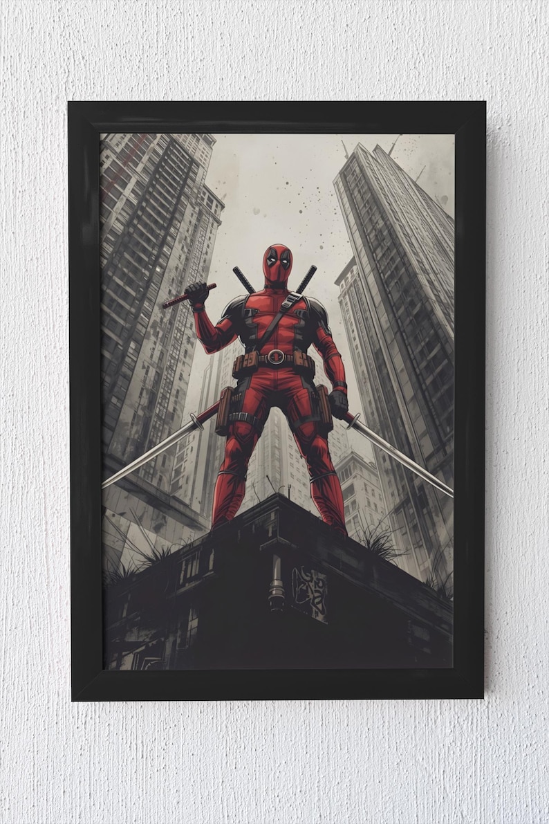 May include: Framed artwork depicting Deadpool in a comic book style. The character, in a red and black suit, holds two katanas, standing on a rooftop with a cityscape backdrop. The artwork is presented in a black frame.