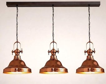 Lámpara colgante industrial de cobre brillante hecha a mano con interior dorado.