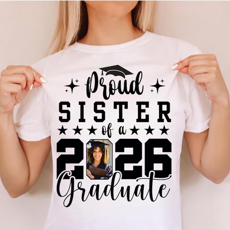 Puede incluir: Camiseta blanca con el texto negro "Proud Sister of a 2026 Graduate". El dise&ntilde;o incluye un gorro de graduaci&oacute;n, estrellas y una foto de una graduada. Un regalo para una hermana orgullosa.