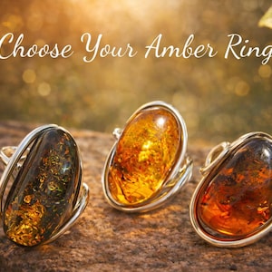 Peut inclure: Trois bagues en ambre avec des montures en argent sont présentées sur une surface texturée. Les pierres d'ambre varient en couleur, allant du brun foncé au jaune doré. Le texte "Choose Your Amber Ring" est écrit en blanc.