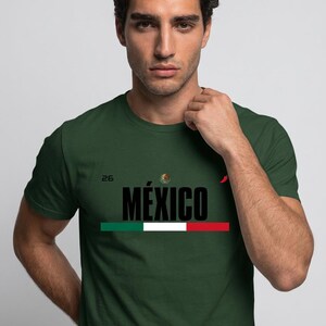 Peut inclure: Un t-shirt vert foncé à manches courtes arborant le mot MÉXICO en lettres noires grasses, un petit emblème national mexicain, le nombre 26, une icône de piment rouge et une bande horizontale verte, blanche et rouge sur la poitrine.