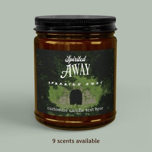 May include: A brown glass jar candle with a black lid. The label features the words "Spirited AWAY" in a decorative font, with additional text and a graphic of a stone archway. The bottom of the label reads "cuztomize candle text here" and "9 scents available."