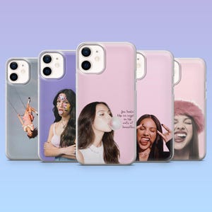 Può includere: Una collezione di custodie per telefoni con immagini di una cantante. Le custodie sono in vari colori, tra cui rosa, viola e trasparente. Alcune custodie hanno immagini della cantante che soffia una bolla, altre hanno testo.