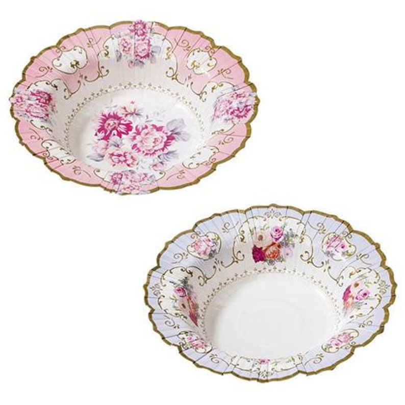 May include: Two decorative paper bowls with scalloped edges. One bowl has a pink rim and floral design, the other has a light blue rim and floral design. Both bowls have a gold trim.