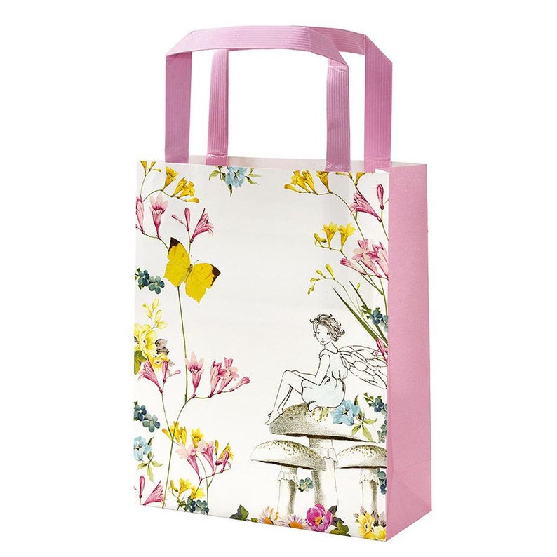 May include: A pink paper gift bag with a white floral design featuring a fairy sitting on a mushroom. The bag has pink handles and a white background with yellow butterflies.