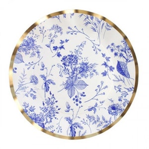 May include: Round white plate with a blue floral pattern and a gold rim. The design features detailed blue botanical illustrations of flowers, leaves, and branches. The plate is suitable for serving food.
