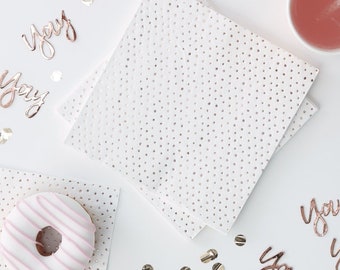 May include: White napkins with silver glitter dots, a pink and white striped donut, and gold confetti on a white background. The image also includes several rose gold foil cutouts that say "yay".