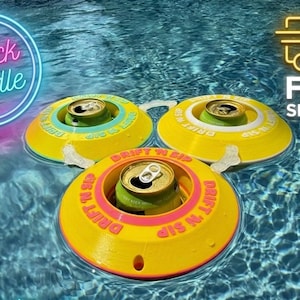 Pode incluir: Três porta-bebidas flutuantes amarelos e rosa com uma lata de refrigerante em cada um, flutuando em uma piscina. O texto "DRIFT N SIP" está impresso nos porta-bebidas. A imagem também inclui um gráfico de "3 pack bundle".