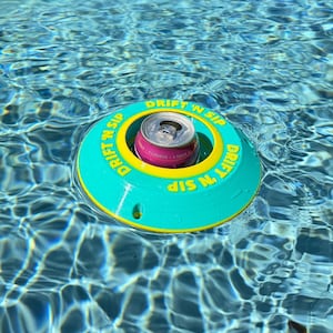 May include: A teal and yellow floating drink holder with the words "DRIFT 'N SIP" in a circular pattern. A pink and silver can sits in the centre of the holder, floating in a pool.