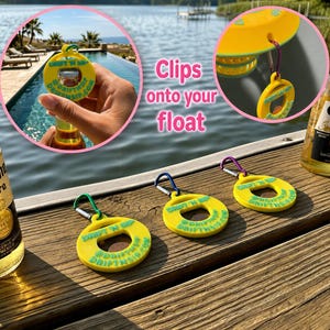 Könnte beinhalten: Gelber Flaschenöffner mit Karabinerhaken, mit dem Text "DRIFT N SIP @DRIFTNSIP.COM". Der Öffner wird mit einer Bierflasche und dem Text "Clips onto your float" gezeigt.