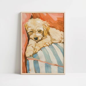 Könnte beinhalten: Gerahmtes Gemälde eines schlafenden Welpen. Der Welpe ist hellbraun, mit geschlossenen Augen, auf einem blau-weiß gestreiften Kissen liegend. Der Hintergrund ist eine Mischung aus Orange- und Rottönen, mit einem hellbraunen Rahmen.
