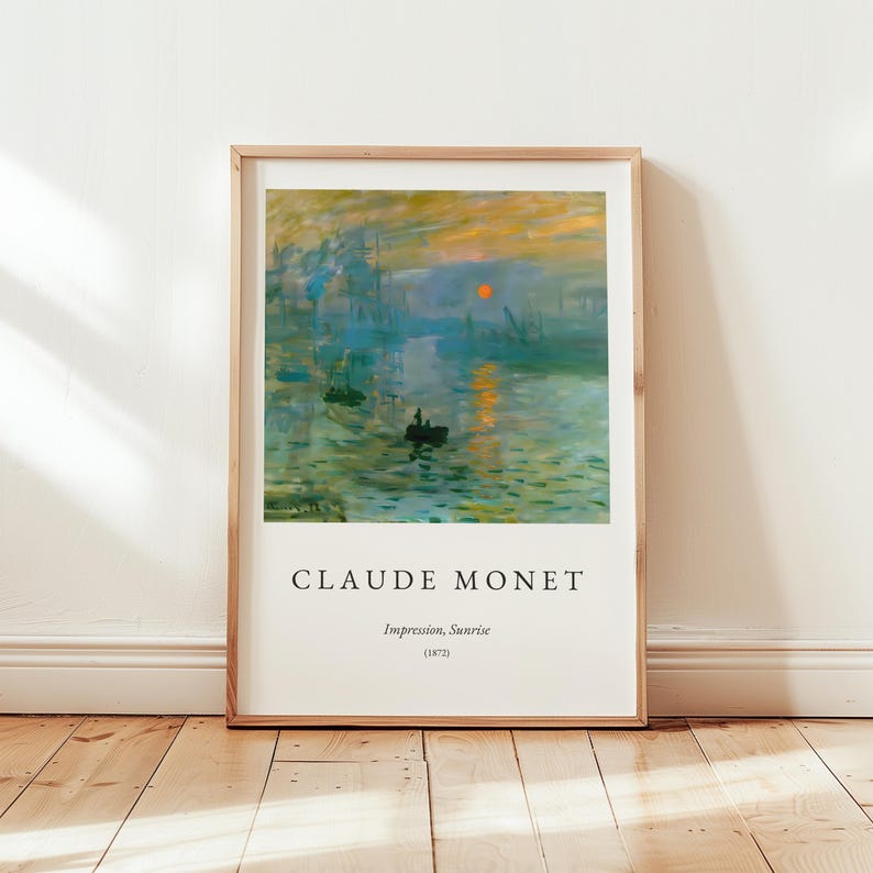 Puede incluir: Una impresi&oacute;n enmarcada de "Impresi&oacute;n, amanecer" (1872) de Claude Monet. La obra representa una escena portuaria al amanecer, con barcos, edificios y un sol naranja vibrante. La impresi&oacute;n est&aacute; en un marco de madera.