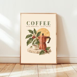 May include: A vertical wall art print on a cream background featuring the text COFFEE SLOW MORNINGS QUIET HOURS. The illustration depicts a red moka pot, a white coffee cup, and a coffee plant branch with red berries resting on a stone base.