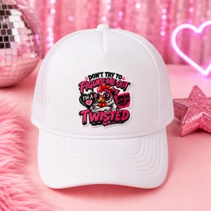 May include: A white trucker hat featuring a graphic of a chicken wearing pink sunglasses and a pink bandana. The text reads: DON'T TRY TO FIGURE ME OUT I'M A SPECIAL KIND OF TWISTED. The design includes pink hearts and bold pink lettering.