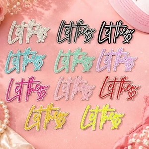 May include: A collection of eleven embroidered patches featuring the cursive text Let them with a small heart icon. The patches are available in various colors including white, black, teal, mint green, lavender, hot pink, light pink, red, and yellow.
