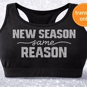 May include: Black sports bra with the text "NEW SEASON same REASON" in white rhinestone-style lettering. An orange circle in the upper right corner reads "transfer only". The bra has a racerback design.