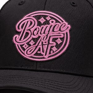 May include: Black baseball cap with a pink embroidered patch. The patch features the word "Boujee" above "AF" in a cursive font, with star accents. The cap has a curved brim and a button on top.