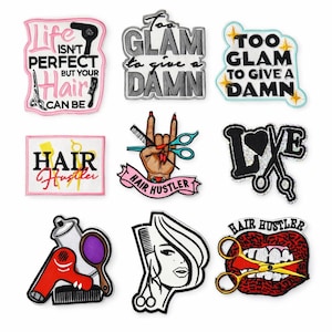 May include: A collection of embroidered patches with various designs and text related to hairstyling. The patches feature phrases like "Life Isn't Perfect But Your Hair Can Be" and "Too Glam to Give a Damn." Other patches include scissors, combs, and a hand gesture.