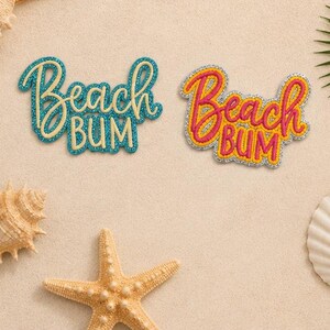May include: Two embroidered patches featuring the text Beach Bum in cursive and block lettering. One patch has teal thread with a light yellow center, and the other has hot pink thread with a yellow center, both outlined in silver metallic thread.