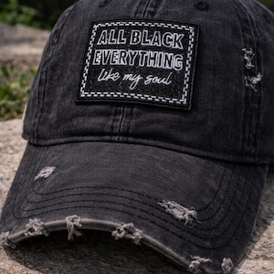 May include: Black distressed baseball cap with the text "ALL BLACK EVERYTHING like my soul" on a patch. The cap has a worn look with distressed details and a curved brim. A casual accessory.