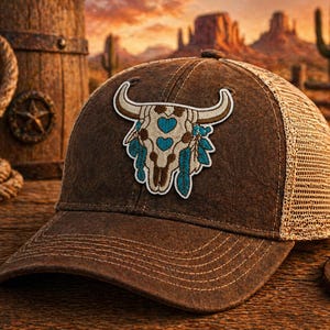 May include: Brown trucker hat with a decorative patch featuring a steer skull with turquoise accents. The hat has a mesh back and a curved brim. Western-themed apparel.