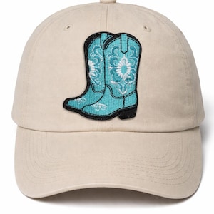May include: A beige baseball cap featuring a turquoise cowboy boot patch with white floral embroidery. The cap has a curved brim and a button on top, offering a classic, casual style.