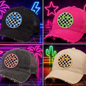 May include: Four distressed trucker hats in black, pink, grey, and tan. Each hat features a circular patch with a checkered smiley face design. The hats have a mesh back and a curved brim.