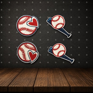 May include: Four baseball-themed patches. Two patches feature a baseball with a red heart, and two show a baseball on a blue bat. The patches have red, white, and blue colors. The background is dark gray with plus signs.