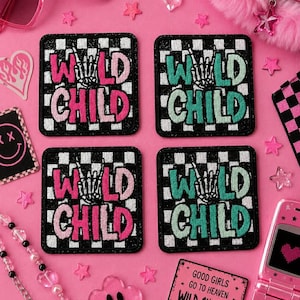 May include: Four square patches with the words "WILD CHILD" in pink and teal, with a hand gesture graphic, on a black and white checkered background. The patches are surrounded by pink accessories, including sunglasses and a flip phone.
