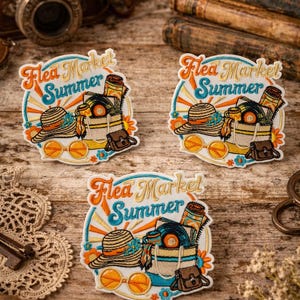 May include: Embroidered patches with the text "Flea Market Summer" in orange and blue. The patches feature a straw hat, sunglasses, records, and a small bag. The patches are on a wooden surface with vintage items in the background.
