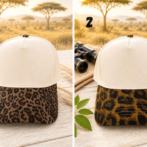 May include: Two baseball caps with a solid off-white crown and a dark brown leopard print brim. Each cap features a small dark button at the top center. The caps are numbered one and two, displaying distinct variations in the leopard print pattern.