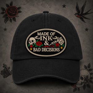 May include: Black baseball cap with an embroidered patch. The patch features the text "MADE OF INK & BAD DECISIONS" with a skull, roses, and a tattoo machine. The cap has a curved brim and a fabric strap.